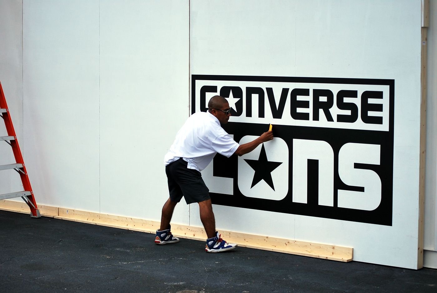 Installing the 8-foot Converse CONS logo at the Wynwood event site before graffiti artists painted around it